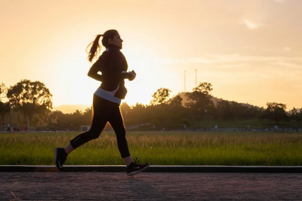 A runner silhouetted on a path at golden hour